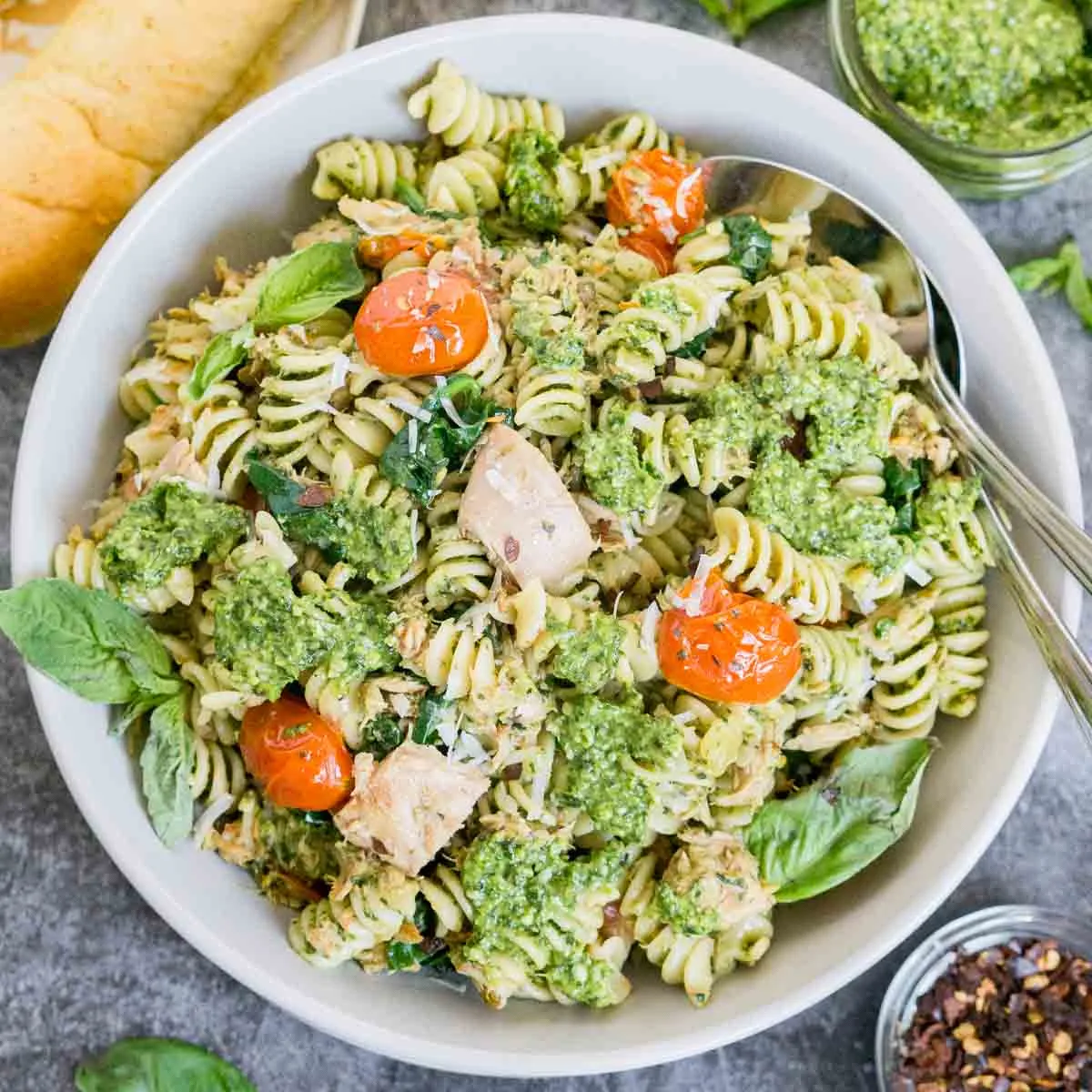 Plate of tuna pesto pasta with garnishes on the side