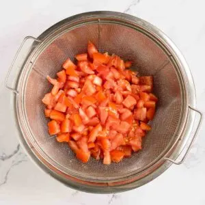 Diced tomatoes draining in a colander