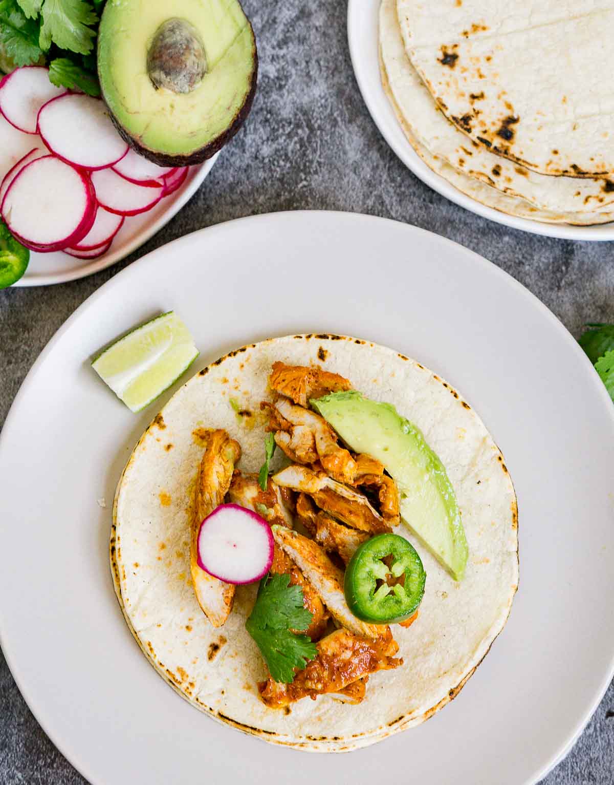 Assembling a chicken taco on a tortilla