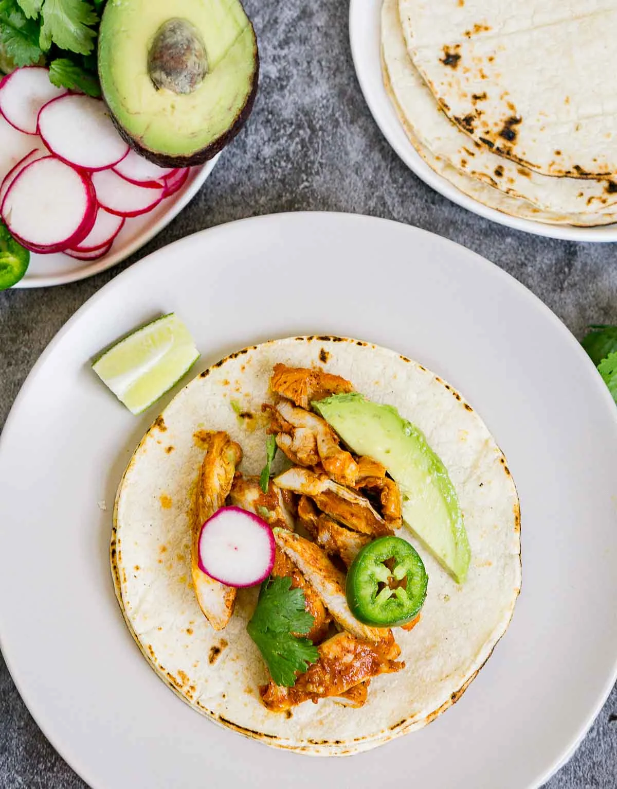 Assembling a chicken taco on a tortilla
