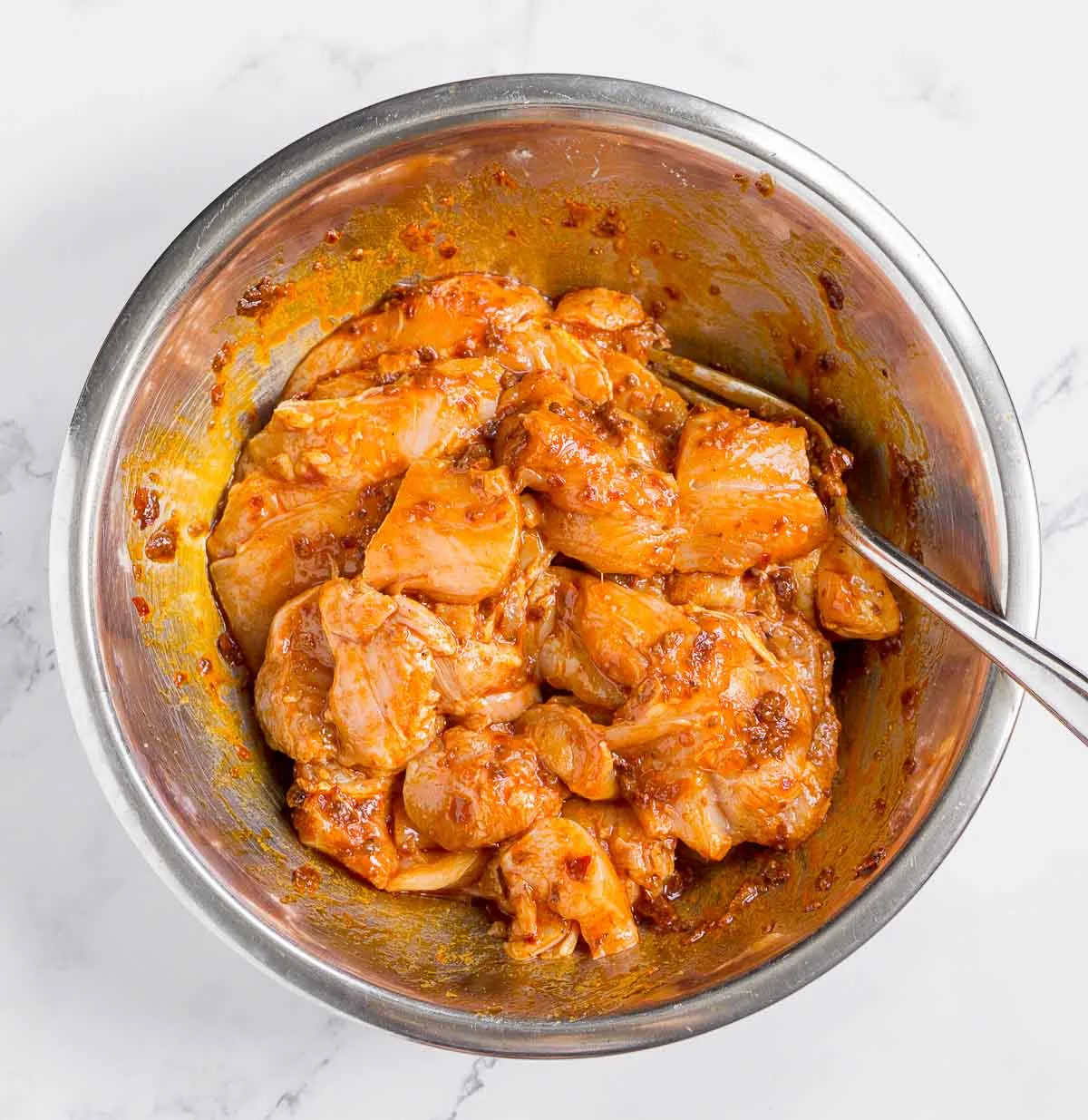 Chicken in harissa paste seasoning in a bowl