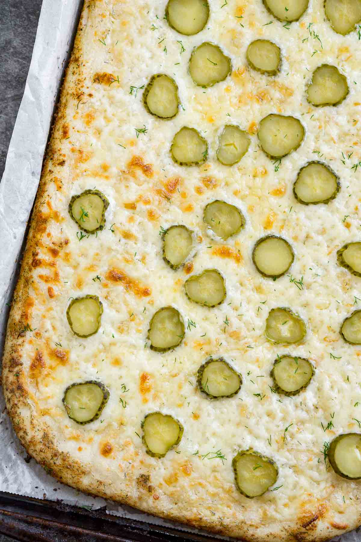 Dill pickle pizza on a baking sheet