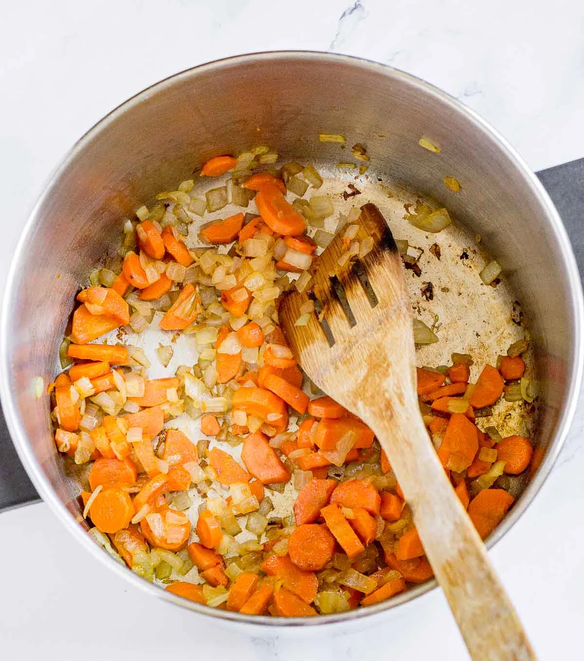 Sauteed carrots and onion in a soup pot