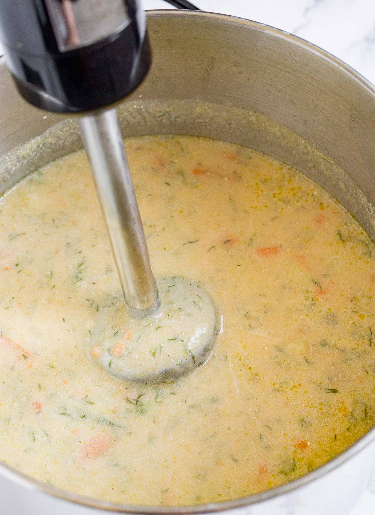 Pureeing potato dill soup with an immersion blender