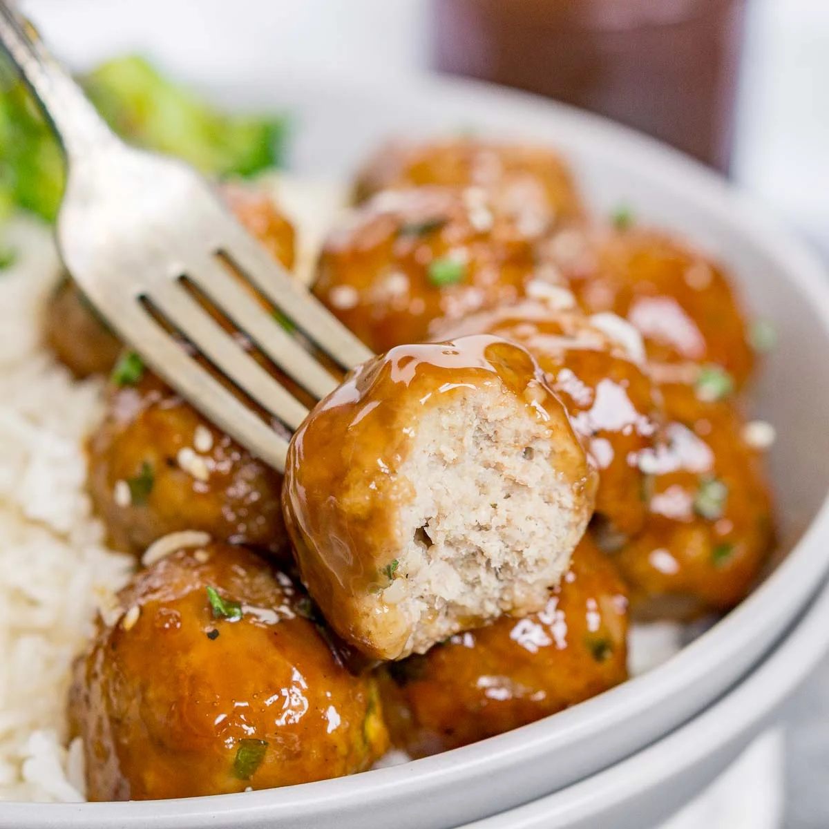 Plate of teriyaki turkey meatballs with one cut in half to show texture