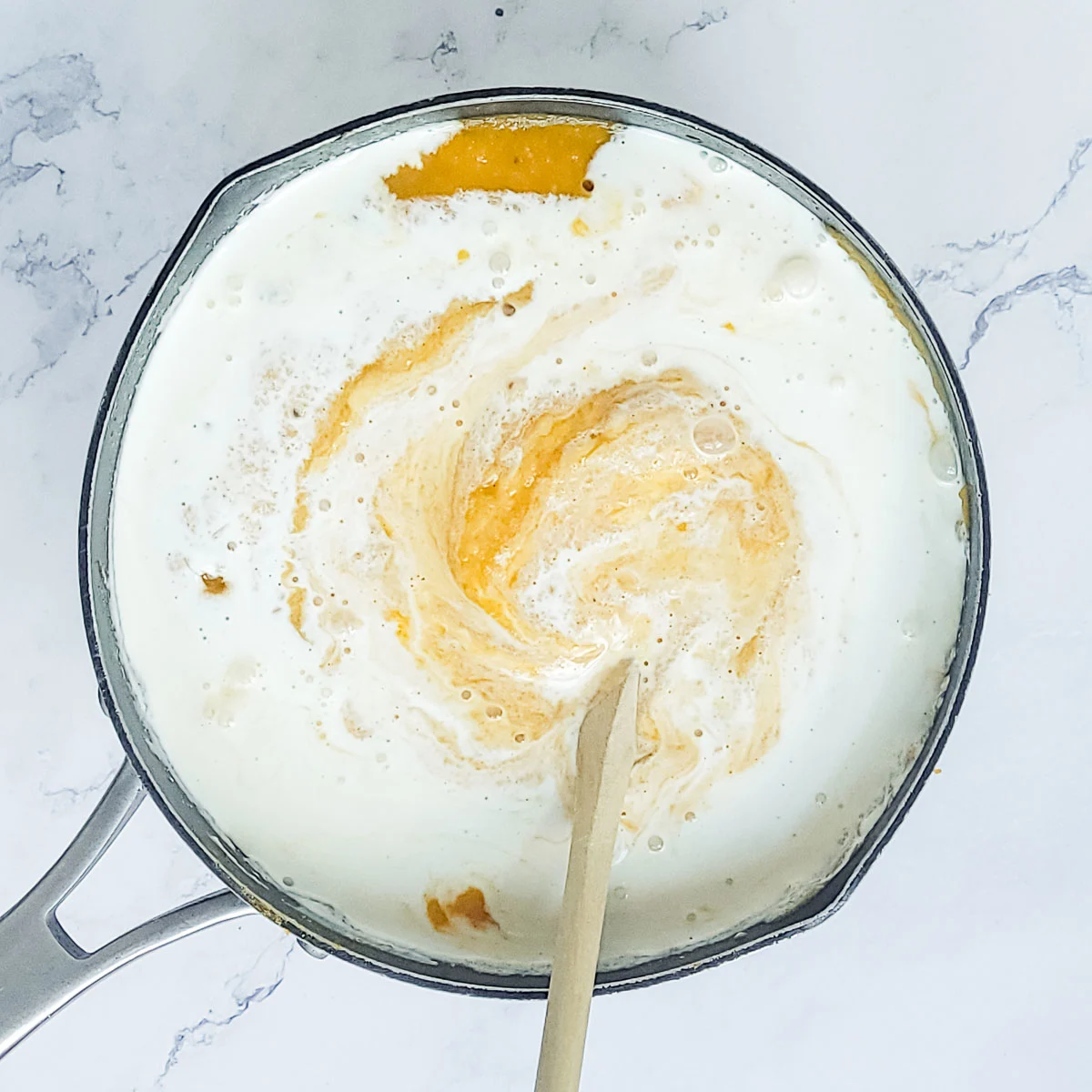 Stirring heavy cream into butternut squash soup
