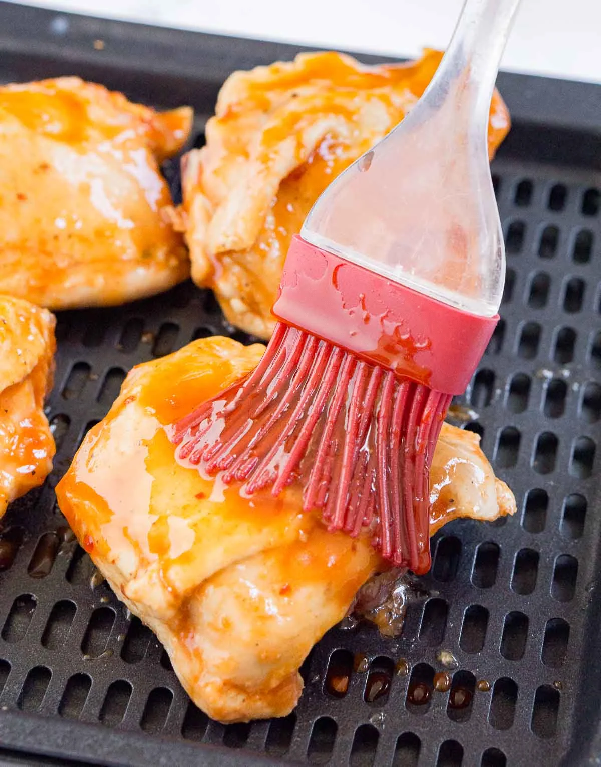 Brushing sauce onto sous vide cooked chicken thighs