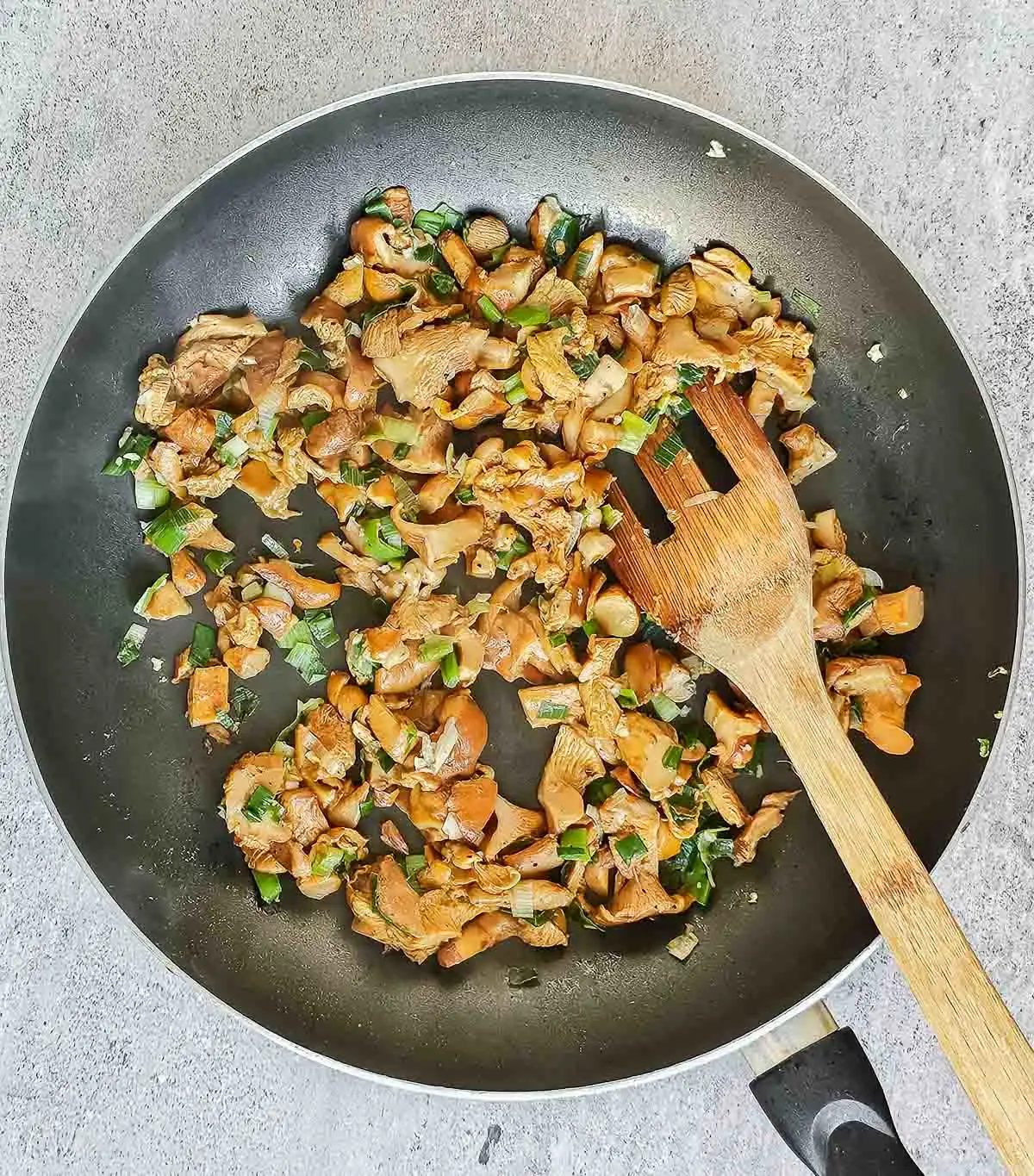 Sauteed chanterelle mushrooms and scallions in a skillet