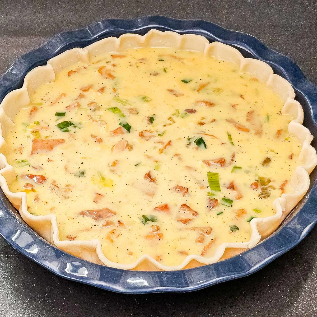 Egg mixture poured into prepared pie dish to make quiche